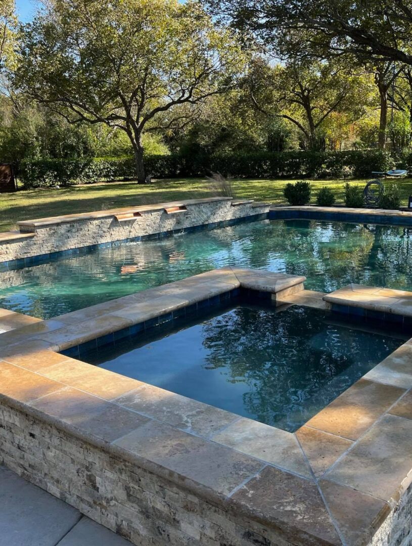 Stone spa adjacent to backyard pool